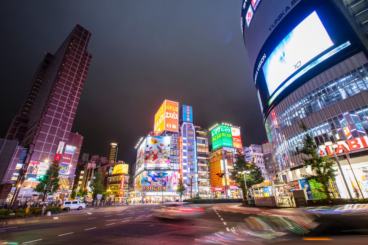 Bright and lively Shinjuku cityscape at night with neon lights and bustling streets.